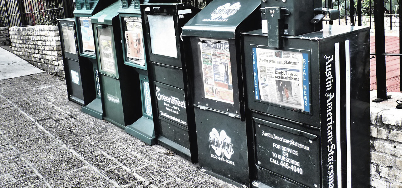 Ce sont des boîtes fermées et vitrées contenant des journaux. On doit mettre de la monnaie dans ces boîtes pour avoir accès aux journaux.