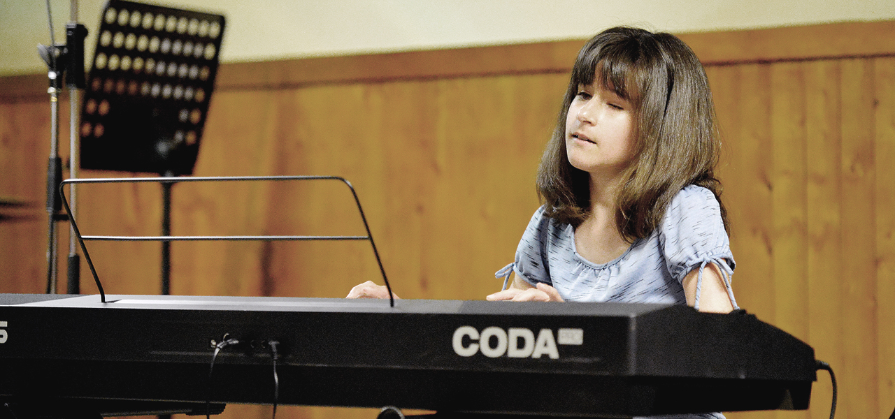 Élève aveugle jouant au piano lors du spectacle organisé par Musique O Max.